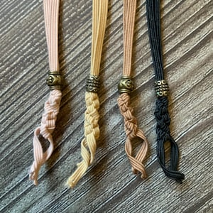 4 notebook insert connectors of different colors.  Each is adorned with its own antique bronze charm.  The connector colors include wheat, tan, coffee, and tan.