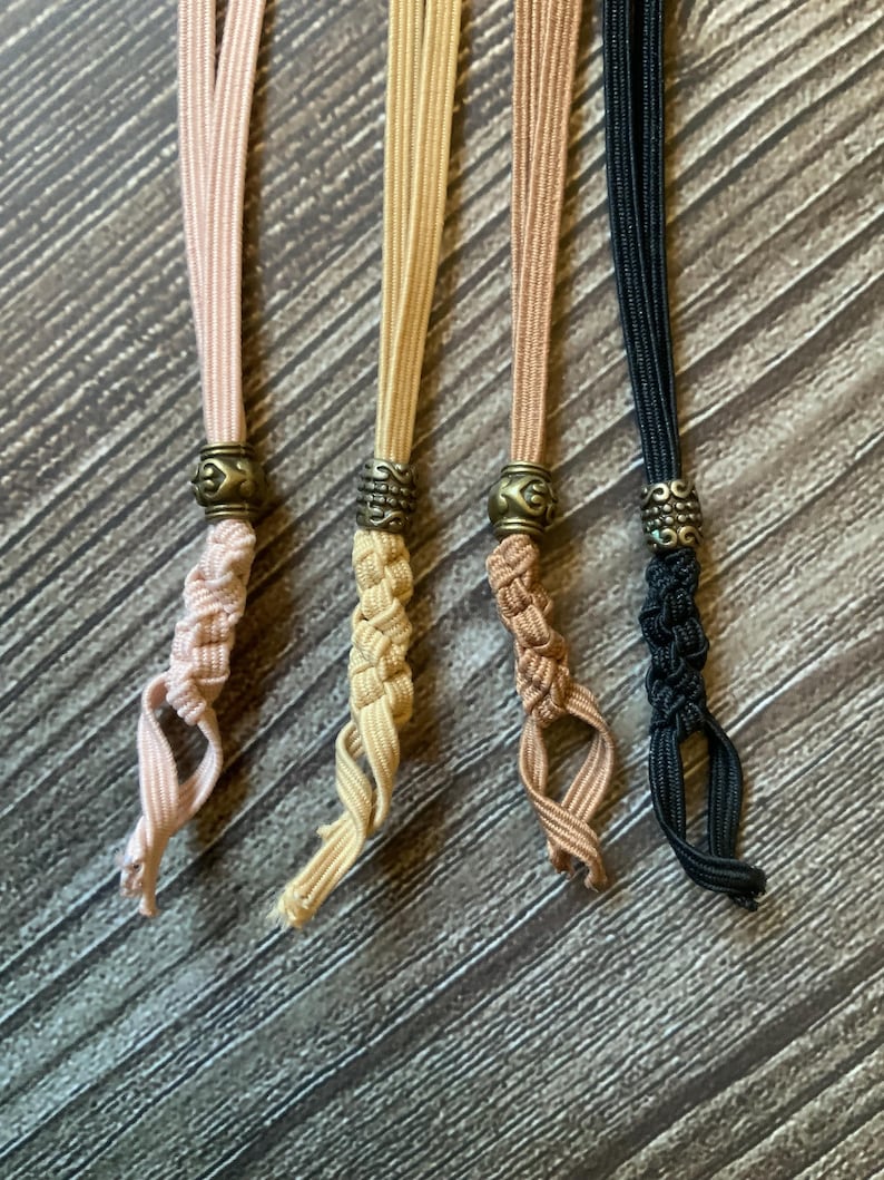 4 notebook insert connectors of different colors.  Each is adorned with its own antique bronze charm.  The connector colors include wheat, tan, coffee, and tan.