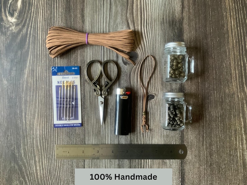 A handmade travelers notebook insert connector surrounded by the tools and materials used to create it.  Additional text at the bottom reads:  100% Handmade