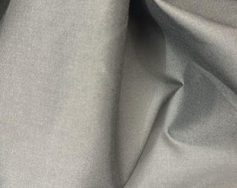 Könnte beinhalten: Nahaufnahme eines schwarzen Stoffes mit einer glatten, leicht strukturierten Oberfläche. Der Stoff ist gefaltet und drapiert und zeigt seine Weichheit und Flexibilität.