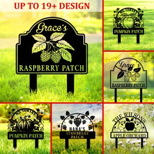 Puede incluir: Señales de jardín de metal negro con varios diseños. Una señal dice "Grace's Raspberry Patch" con una ilustración de frambuesa. Otras señales incluyen "Pumpkin Patch", "Strawberry Patch" y "Apple Orchard". Las señales se muestran sobre un fondo de hierba.