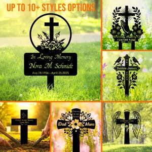 May include: A selection of black metal memorial crosses with different styles. One cross has a circular design with a cross and the text "In Loving Memory Nora M Schmidt". Other crosses feature floral and angel wing motifs.