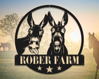 May include: A black metal sign with two donkeys, one sticking its tongue out and the other laughing. The sign says "ROBER FARM" with three stars below the text.