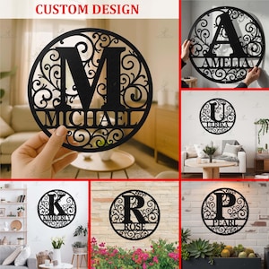 May include: Black metal custom design wall art. The circular design features a large letter with a name below, surrounded by decorative scrollwork. The text "CUSTOM DESIGN" is at the top. Examples include "M MICHAEL", "A AMELIA", "U URIKA", "K KIMBERLY", "R ROSE", and "P PEARL".