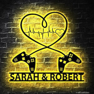 May include: A neon sign with a heart shape and a heartbeat graphic. The sign also features two video game controllers and the text "SARAH & ROBERT".