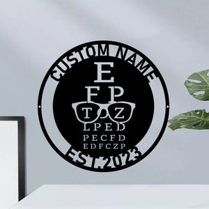 May include: Black and white metal eye chart sign with the text "Custom Name Est 2023" around the edge. The eye chart includes the letters E, FP, TOZ, LPED, PECFD, EDFCZP.