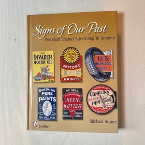 May include: A hardcover book titled "Signs of Our Past: Porcelain Enamel Advertising in America." The cover features vintage advertising signs for motor oil, paints, tires, and pens. The book is by Michael Bruner.