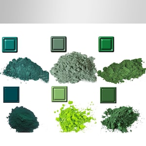 Puede incluir: Una variedad de polvos verdes en diversos tonos, desde turquesa hasta verde bosque profundo. Cada montón de polvo está acompañado por un cuadrado del color correspondiente, creando una presentación de paleta de colores. Los polvos parecen finamente molidos y texturizados.