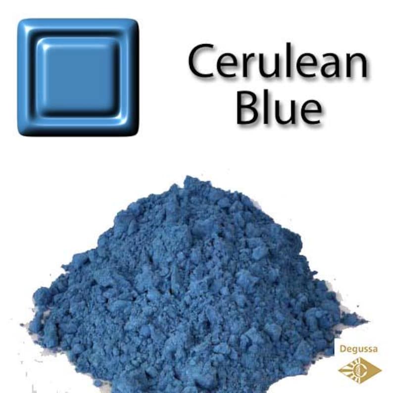 Może przedstawiać: Stos proszku pigmentu w kolorze błękitu ceruleanu z błyszczącym niebieskim kwadratem w lewym g&oacute;rnym rogu. Słowa "Cerulean Blue" są napisane czarnym tekstem. Logo Degussa znajduje się w prawym dolnym rogu.