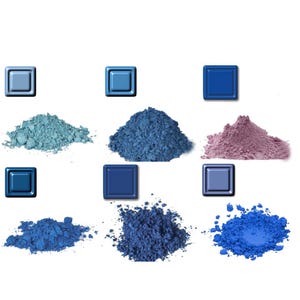 Op de afbeelding: Een assortiment blauwe en paarse pigmentpoeders met bijpassende vierkante kleurstalen. De poeders variëren in tint van lichtblauw tot diep indigo en paars. De afbeelding is tegen een witte achtergrond.