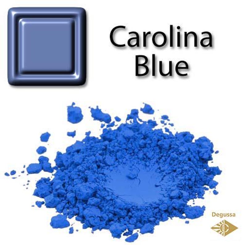 Może przedstawiać: Kwadrat farby Carolina Blue obok stosu tego samego pigmentu. Proszek ma żywy niebieski kolor, z kwadratową pr&oacute;bką tego samego koloru w lewym g&oacute;rnym rogu. Tekst "Carolina Blue" jest wyświetlany na czarno.