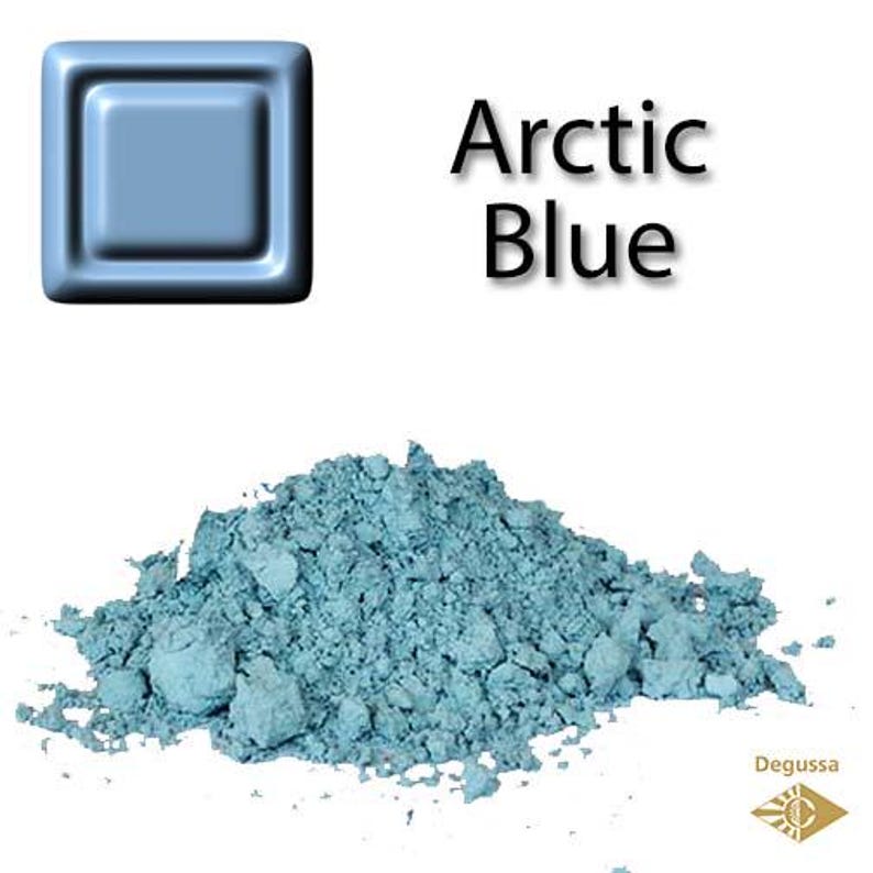 Może przedstawiać: Pr&oacute;bka proszku pigmentowego Arctic Blue, z kwadratową pr&oacute;bką koloru powyżej. Proszek ma jasno niebiesko-zielony kolor, o szorstkiej, ziarnistej fakturze. Słowa "Arctic Blue" są wydrukowane czarnym tekstem. Logo Degussa znajduje się w prawym dolnym rogu.