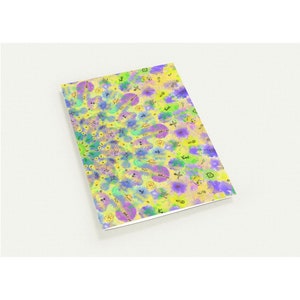 May include: A rectangular notebook with a colorful abstract design. The cover features a yellow background with blue, purple, and green watercolor-style shapes and patterns. The notebook is angled slightly, showing its edge.