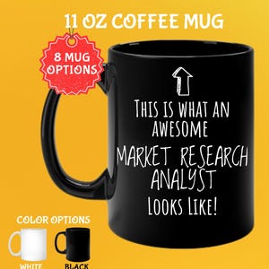Peut inclure: Mug noir de 325 ml avec le texte "THIS IS WHAT AN AWESOME MARKET RESEARCH ANALYST LOOKS LIKE !" en blanc. La tasse a une anse noire et est posée sur un fond jaune. Options de couleurs : blanc et noir.