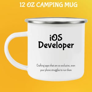 May include: White 355 ml camping mug with a silver rim and handle. The mug features the text "iOS Developer" in black, along with a humorous quote about app development. The mug is designed for outdoor use.