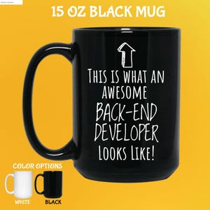 Op de afbeelding: Zwarte mok van 444 ml met de tekst "THIS IS WHAT AN AWESOME BACK-END DEVELOPER LOOKS LIKE!" in het wit. De mok heeft een groot oor en wordt getoond met witte en zwarte kleuropties.