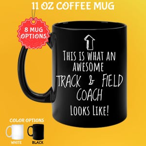 May include: Black 11 oz coffee mug with the text "THIS IS WHAT AN AWESOME TRACK & FIELD COACH LOOKS LIKE!" in white. The mug has a black handle and the words "8 MUG OPTIONS" on a red tag. Color options are white and black.