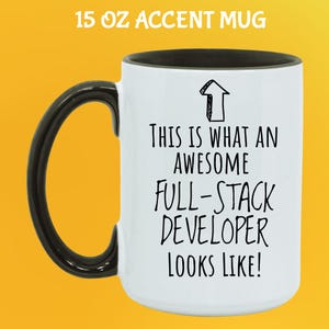 Pu&ograve; includere: Tazza bianca da 444 ml con manico e bordo neri. La tazza presenta la scritta "THIS IS WHAT AN AWESOME FULL-STACK DEVELOPER LOOKS LIKE!" e una grafica a freccia. La tazza &egrave; su sfondo giallo.