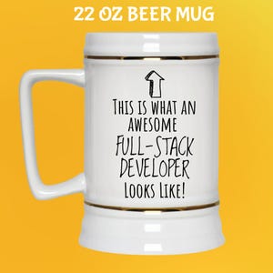 Pu&ograve; includere: Bicchiere da birra bianco da 650 ml con finiture dorate e manico. Il bicchiere ha il testo "THIS IS WHAT AN AWESOME FULL-STACK DEVELOPER LOOKS LIKE!" in nero. Il bicchiere &egrave; su sfondo giallo.