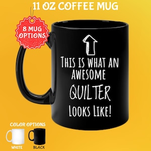 May include: Black 11 oz coffee mug with the text "THIS IS WHAT AN AWESOME QUILTER LOOKS LIKE!" in white. The mug has a black handle and a white arrow graphic. Color options include white and black mugs.