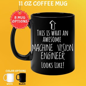 Può includere: Tazza da caffè nera da 325 ml con la scritta "THIS IS WHAT AN AWESOME MACHINE VISION ENGINEER LOOKS LIKE!". Opzioni colore: tazze bianche e nere. Un'etichetta rossa indica "8 MUG OPTIONS".