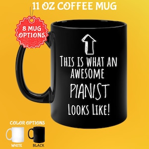 May include: Black 11 oz coffee mug with the text "THIS IS WHAT AN AWESOME PIANIST LOOKS LIKE!" in white. The mug has a black handle and a white arrow graphic. Color options include white and black mugs.