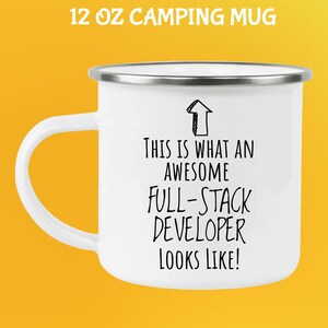 Pu&ograve; includere: Tazza da campeggio bianca da 355 ml con bordo e manico argentati. La tazza presenta il testo "THIS IS WHAT AN AWESOME FULL-STACK DEVELOPER LOOKS LIKE!" in nero, con una grafica a freccia. La tazza &egrave; su sfondo giallo.