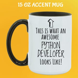 Op de afbeelding: Witte 444 ml mok met een zwarte handgreep en binnenkant. De mok heeft de tekst "THIS IS WHAT AN AWESOME PYTHON DEVELOPER LOOKS LIKE!" in het zwart, met een pijlgrafiek. De mok staat op een gele achtergrond.