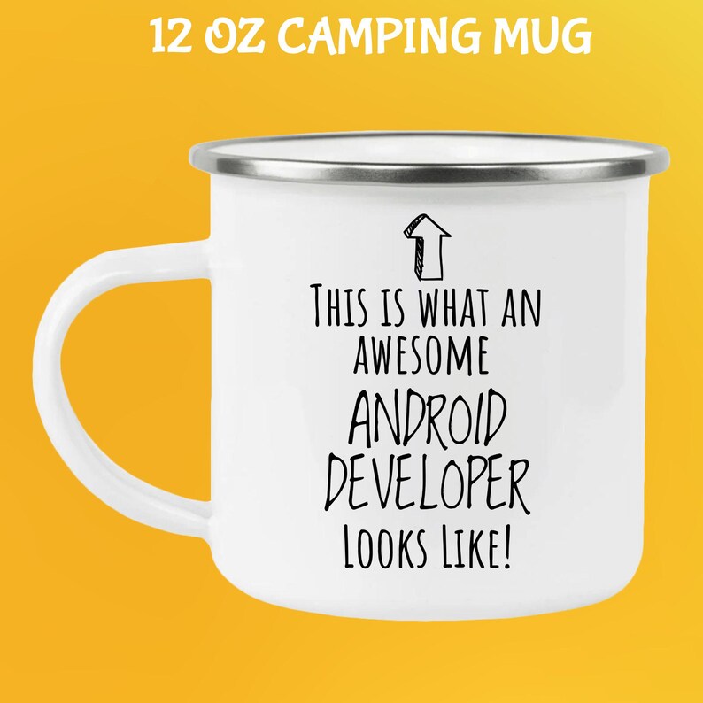 K&ouml;nnte beinhalten: Wei&szlig;er 355 ml Campingbecher mit silbernem Rand und Henkel. Der Becher tr&auml;gt den schwarzen Text "THIS IS WHAT AN AWESOME ANDROID DEVELOPER LOOKS LIKE!" mit einer nach oben zeigenden Pfeilgrafik.