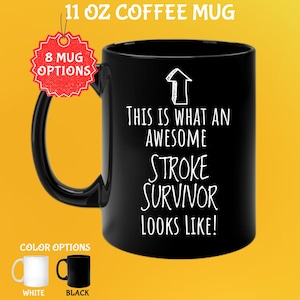 Può includere: Tazza da caffè nera da 325 ml con la scritta bianca "THIS IS WHAT AN AWESOME STROKE SURVIVOR LOOKS LIKE!". La tazza ha un manico nero e l'immagine mostra le opzioni di colore bianco e nero. La tazza ha una grafica a freccia bianca.