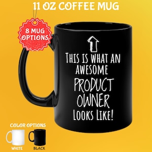May include: Black 11 oz coffee mug with the text "THIS IS WHAT AN AWESOME PRODUCT OWNER LOOKS LIKE!" in white. The mug has a black handle and a white arrow graphic. Additional color options are white and black.