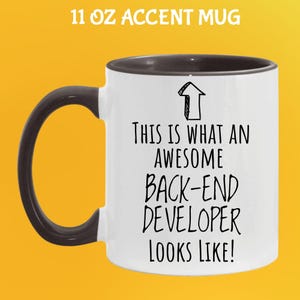 Op de afbeelding: Witte 325 ml accent mok met een zwarte handgreep en binnenkant. De mok heeft de tekst "THIS IS WHAT AN AWESOME BACK-END DEVELOPER LOOKS LIKE!" in het zwart, met een pijl omhoog.