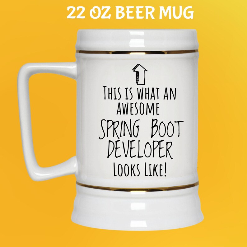 May include: White 650 ml beer mug with gold trim and a handle. The mug has the text "THIS IS WHAT AN AWESOME SPRING BOOT DEVELOPER LOOKS LIKE!" in black. The text is centered on the mug.