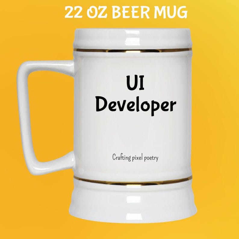 Puede incluir: Taza de cerveza blanca de 650 ml con ribete dorado y asa. La taza tiene las palabras "UI Developer" en negro, con "Crafting pixel poetry" debajo. La taza est&aacute; sobre un fondo amarillo.