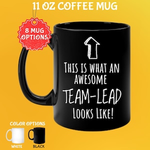 May include: Black 11 oz coffee mug with the text "THIS IS WHAT AN AWESOME TEAM-LEAD LOOKS LIKE!" in white. The mug has a black handle and is shown with white and black color options.