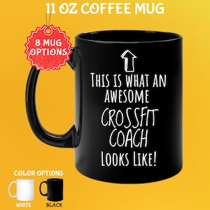 May include: Black 11 oz coffee mug with the text "THIS IS WHAT AN AWESOME CROSSFIT COACH LOOKS LIKE!" in white. The mug has a black handle and is labeled with "8 MUG OPTIONS". Color options are white and black.