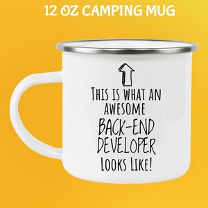Op de afbeelding: Witte 355 ml campingmok met een zilveren rand en een wit handvat. De mok heeft de tekst "THIS IS WHAT AN AWESOME BACK-END DEVELOPER LOOKS LIKE!" in zwart, met een omhoog wijzende pijlgrafiek.