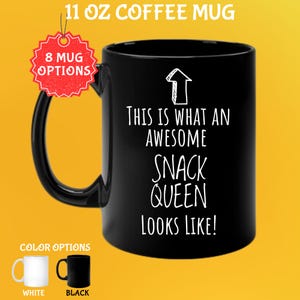 May include: Black 11 oz coffee mug with the text "THIS IS WHAT AN AWESOME SNACK QUEEN LOOKS LIKE!" in white. The mug has a black handle and the words "8 MUG OPTIONS" are visible. Color options are white and black.