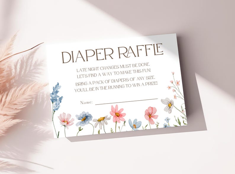 May include: A white card with the text "DIAPER RAFFLE" in brown lettering. The card has a floral design with pink, blue, and white flowers. The text below the title reads "Late night changes must be done. Let's find a way to make this fun. Bring a pack of diapers of any size. You'll be in the running to win a prize." There is a blank line for a name.