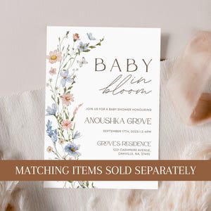 May include: A white baby shower invitation with a floral border. The text reads "Baby in Bloom" and includes the details of the event: "Join us for a baby shower honouring Anoushka Grove, September 17th, 2025, 2-4pm, Groves Residence, 1221 Cashmere Avenue, Oakville, NA, 37495". The bottom of the invitation reads "Matching items sold separately."