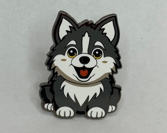 May include: A black and white cartoon husky puppy pin with a happy expression. The pin has a white outline and a black background.