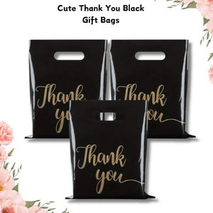 May include: Three black gift bags with die-cut handles. Each bag features the words "Thank you" in gold script. The bags are grouped together, with the text "Cute Thank You Black Gift Bags" at the top.