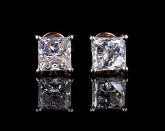 May include: A pair of silver earrings with square-shaped clear cubic zirconia stones.