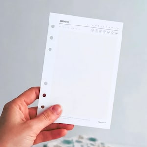 Könnte beinhalten: Eine weiße Einlage für einen Tagesplaner mit sechs vorgestanzten Löchern an der linken Seite. Die Kopfzeile enthält den Text DAILY NOTES, eine Datumszeile, die Monate J F M A M J J A S O N D und Wettersymbole. Unten rechts steht der Text Okprinted.