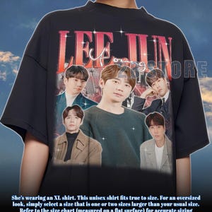 May include: Black unisex t-shirt featuring a vintage-style graphic of a man with the text "LEE JUN". The shirt has a crew neck and short sleeves. The graphic includes multiple images of the man. The shirt is an XL size.