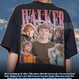 May include: Black unisex t-shirt featuring a collage of images and the name "WALKER" in a pink and white retro font. The shirt has a crew neck and short sleeves. The shirt is a vintage style.