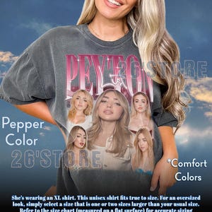 May include: Pepper color unisex t-shirt with a graphic of a woman's face and the text "PEYTON" in pink. The shirt also has the text "26'STORE" and "Comfort Colors".