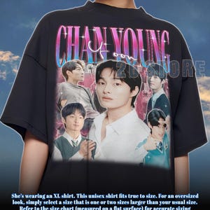 May include: Black unisex t-shirt featuring a graphic of a man with the text "CHAN YOUNG" in a pink and blue font. The shirt has a crew neck and short sleeves. The shirt is made of a soft material.