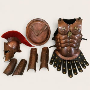 May include: A copper-colored suit of armor including a Corinthian-style helmet with a red crest, a circular shield, a breastplate featuring a central Medusa emblem and two small serpent accents, two greaves, and two bracers with leather straps.