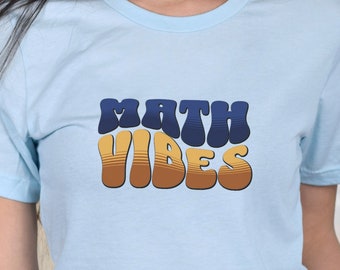 May include: A light blue t-shirt with the text "MATH VIBES" in a retro, colourful font.